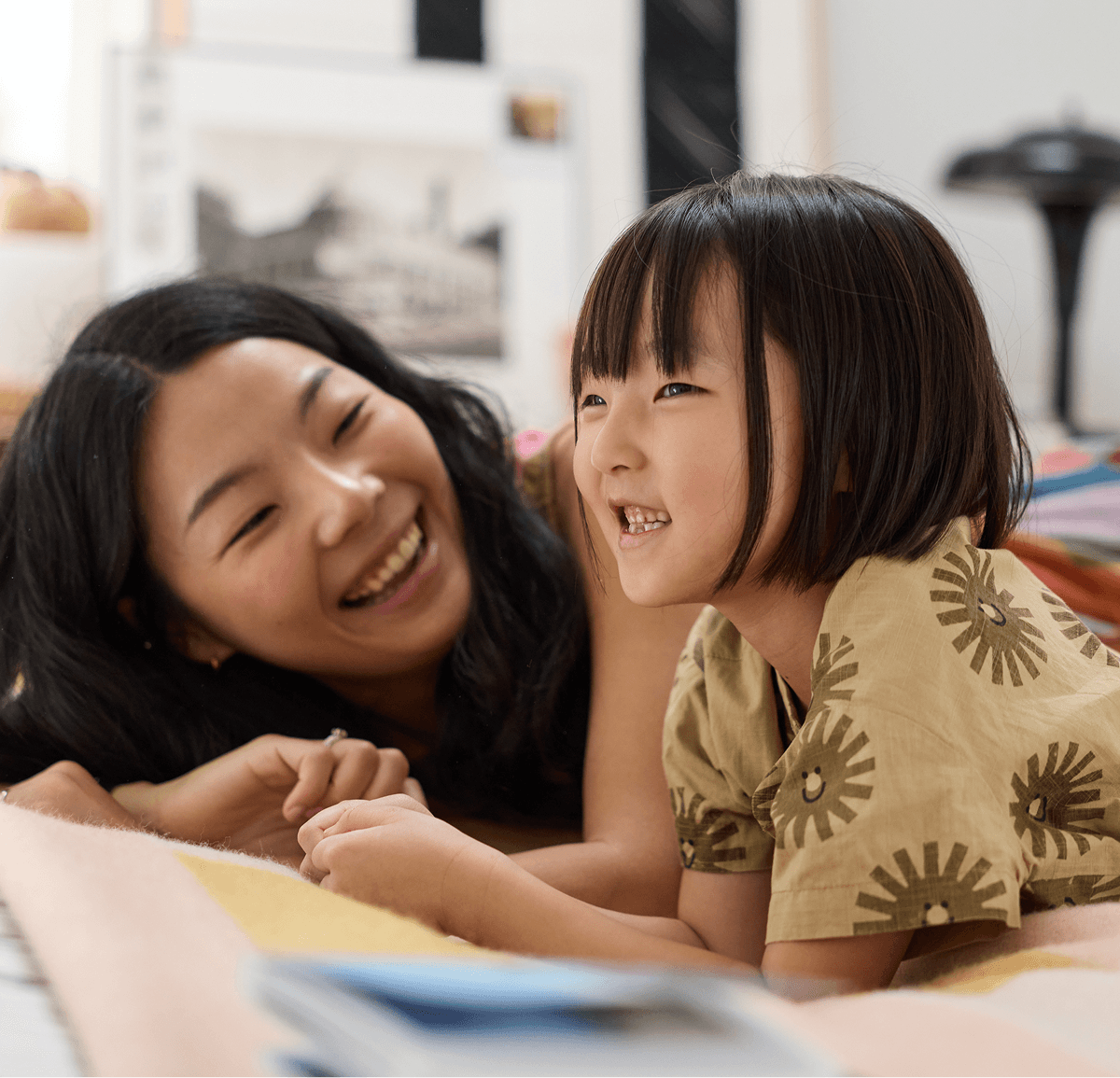 Mom and child smiling while looking at a Monthbook together