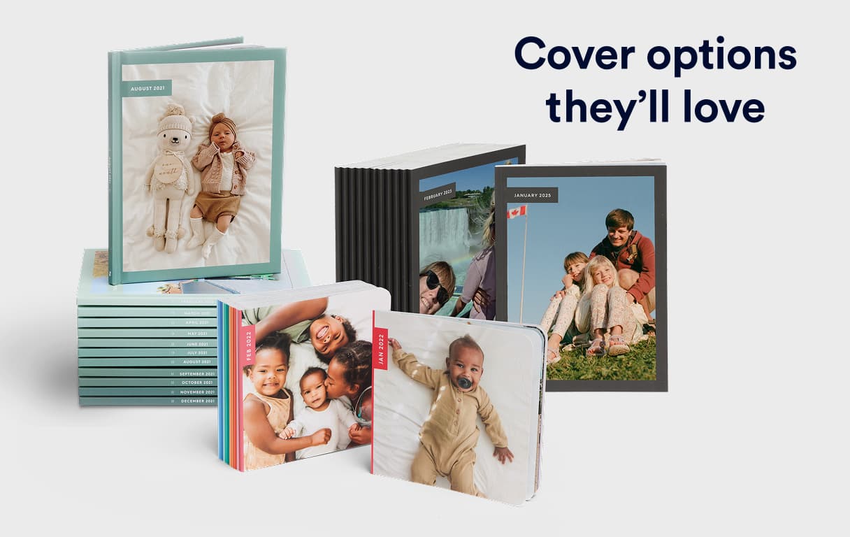 A stack of square monthly photo books next to a gift-wrapped photo book featuring a printed cover and a red ribbon.