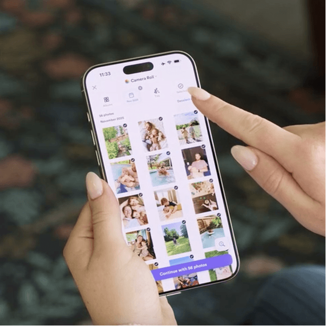 Hands holding a phone selecting photos in the Chatbooks app