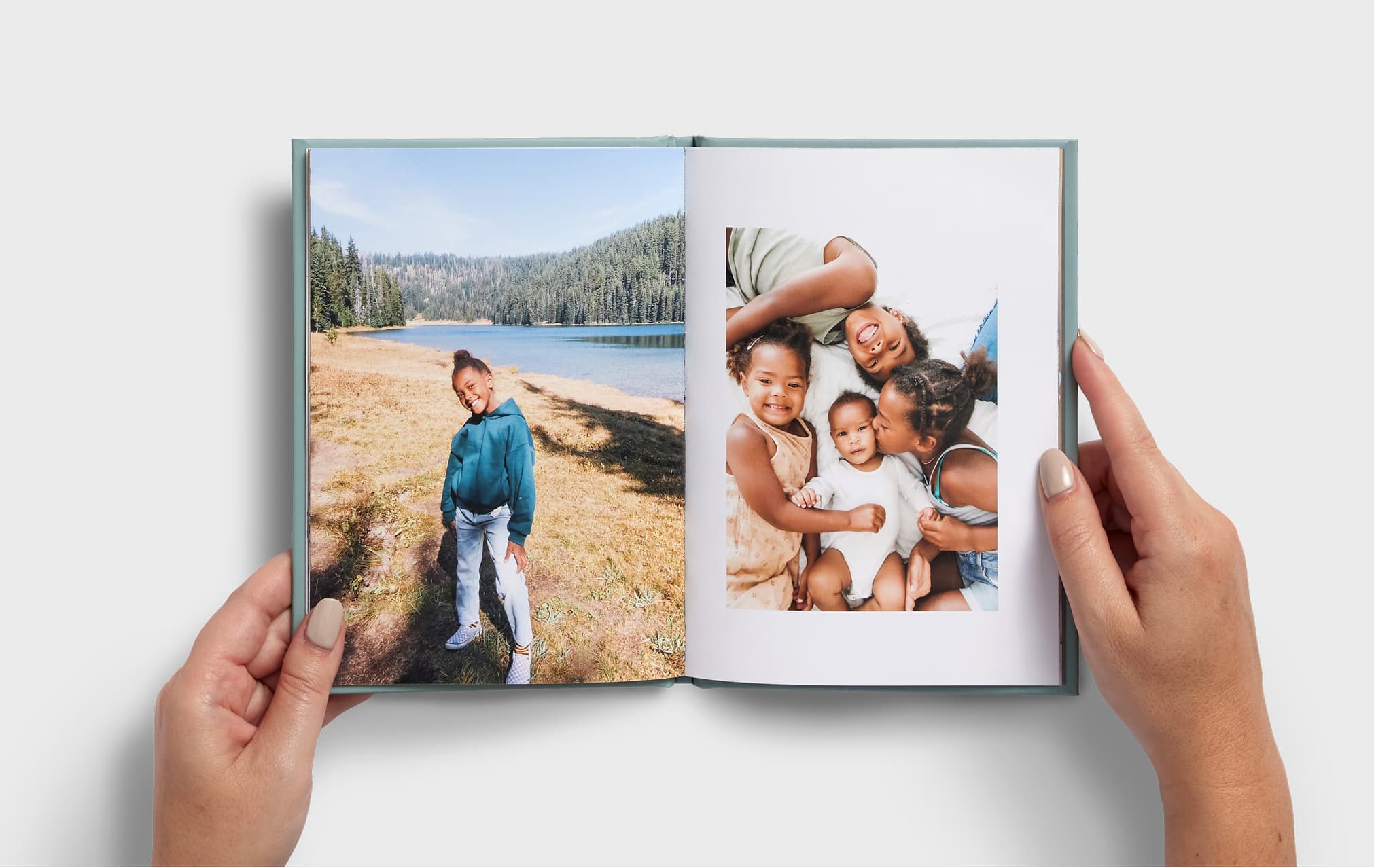 Open photo book showing a young child eating ice cream on one page and riding a carousel with an adult on the other, with a Minnie Mouse image partially visible nearby.