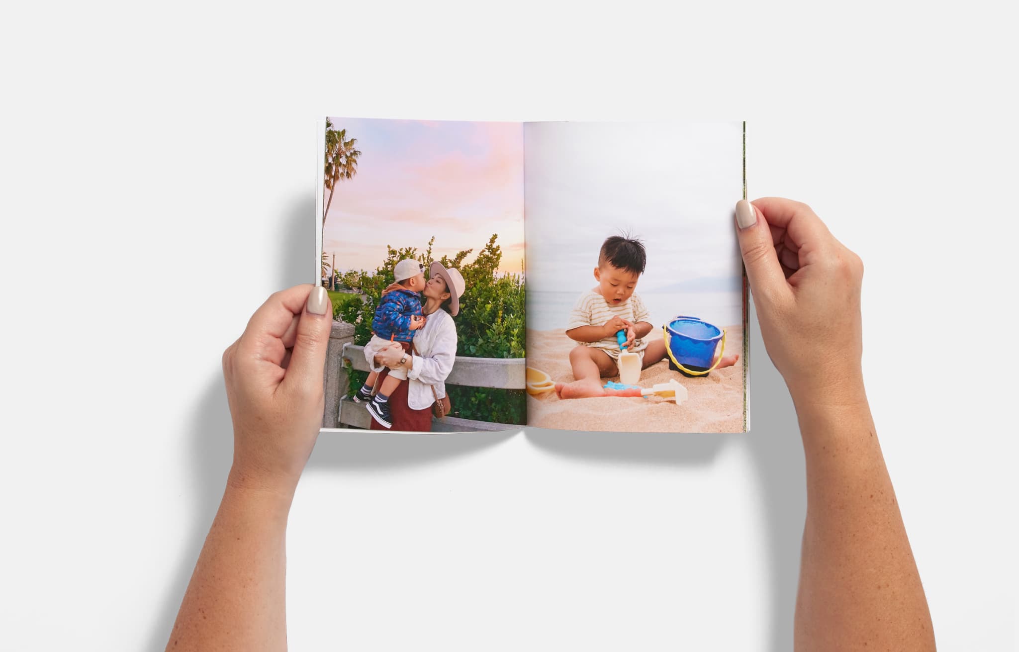 Open photo book showing a young child eating ice cream on one page and riding a carousel with an adult on the other, with a Minnie Mouse image partially visible nearby.